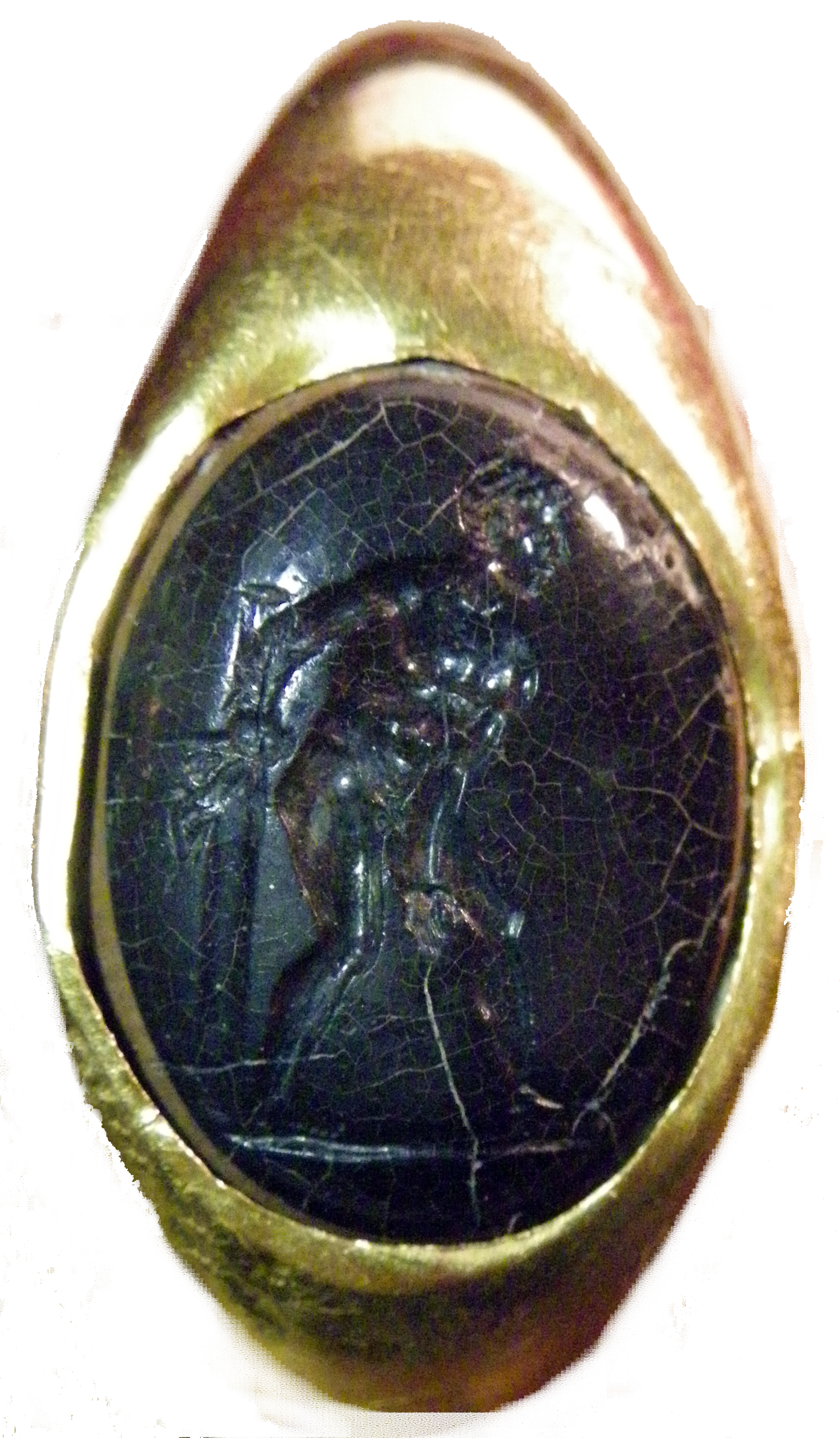 Bague à intaille, vue d'en haut. La bague est dorée. L'intaille est bleue foncée, presque noire. Elle est très fissurée. On y voit un personnage masculin, nu, de profil, tourné vers la droite. Il s'agit d'Ulysse, le héro antique.